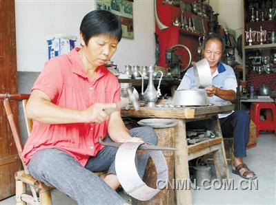 9月5日，江冬桂在锡器作坊里娴熟地锻打锡器坯件。