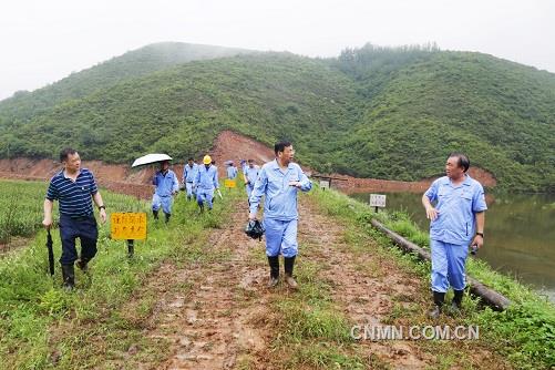 第三张：万基控股集团董事长李跃民（左二）检查万基发电公司山口灰库堤坝加固情况